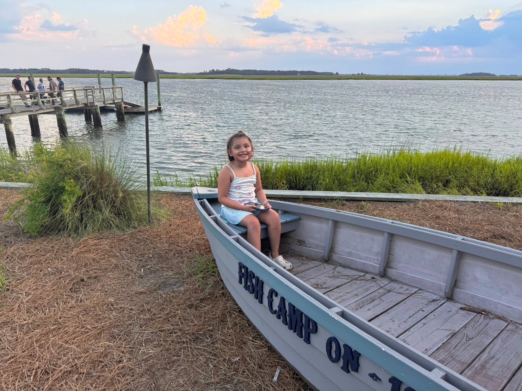 Youngest of the City Star family smiling in a marsh-side fishing boat at sunset
